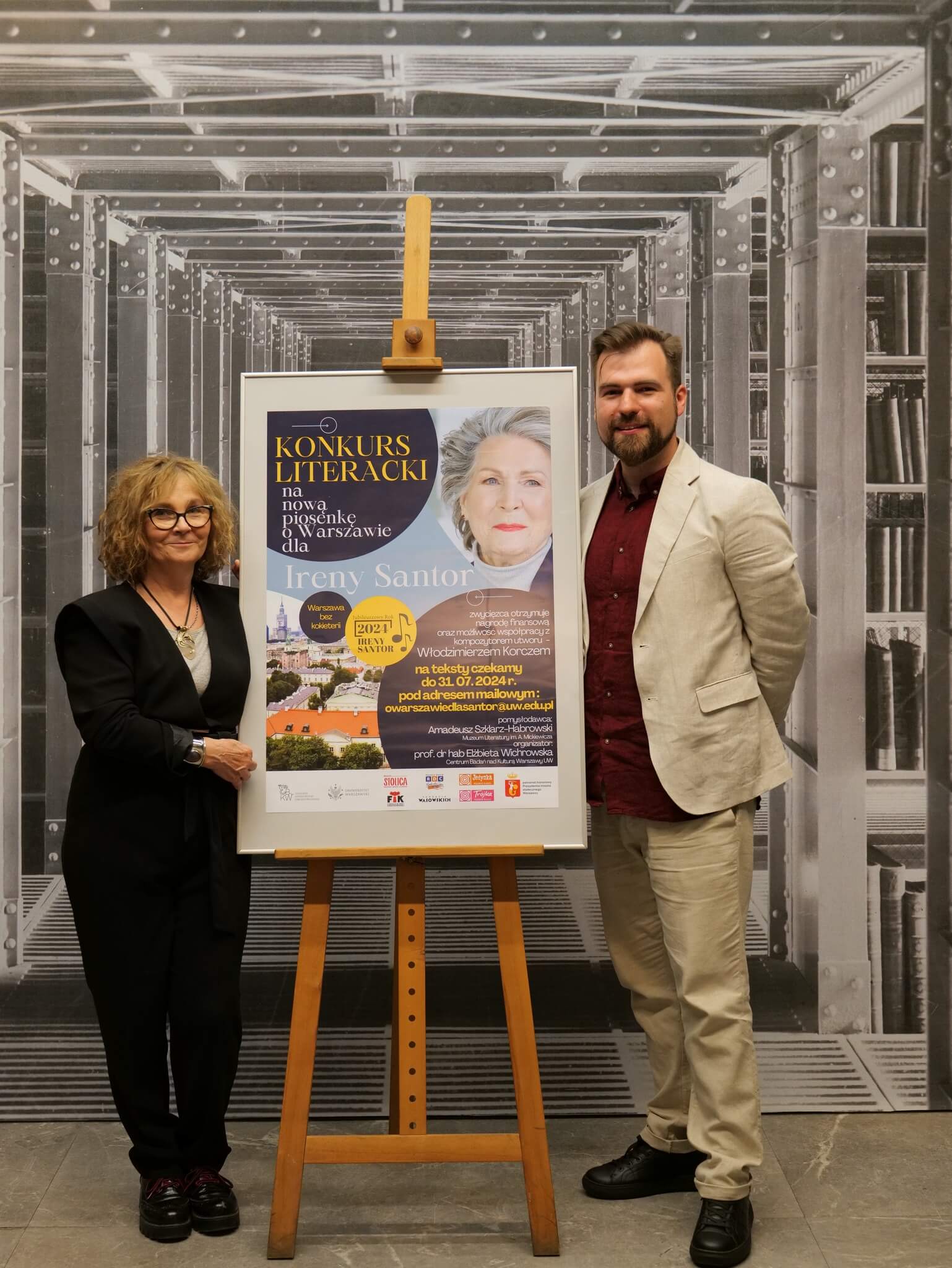 prof. Elżbieta Wichrowska i Amadeusz Szklarz-Habrowski obok plakatu konkursowego.