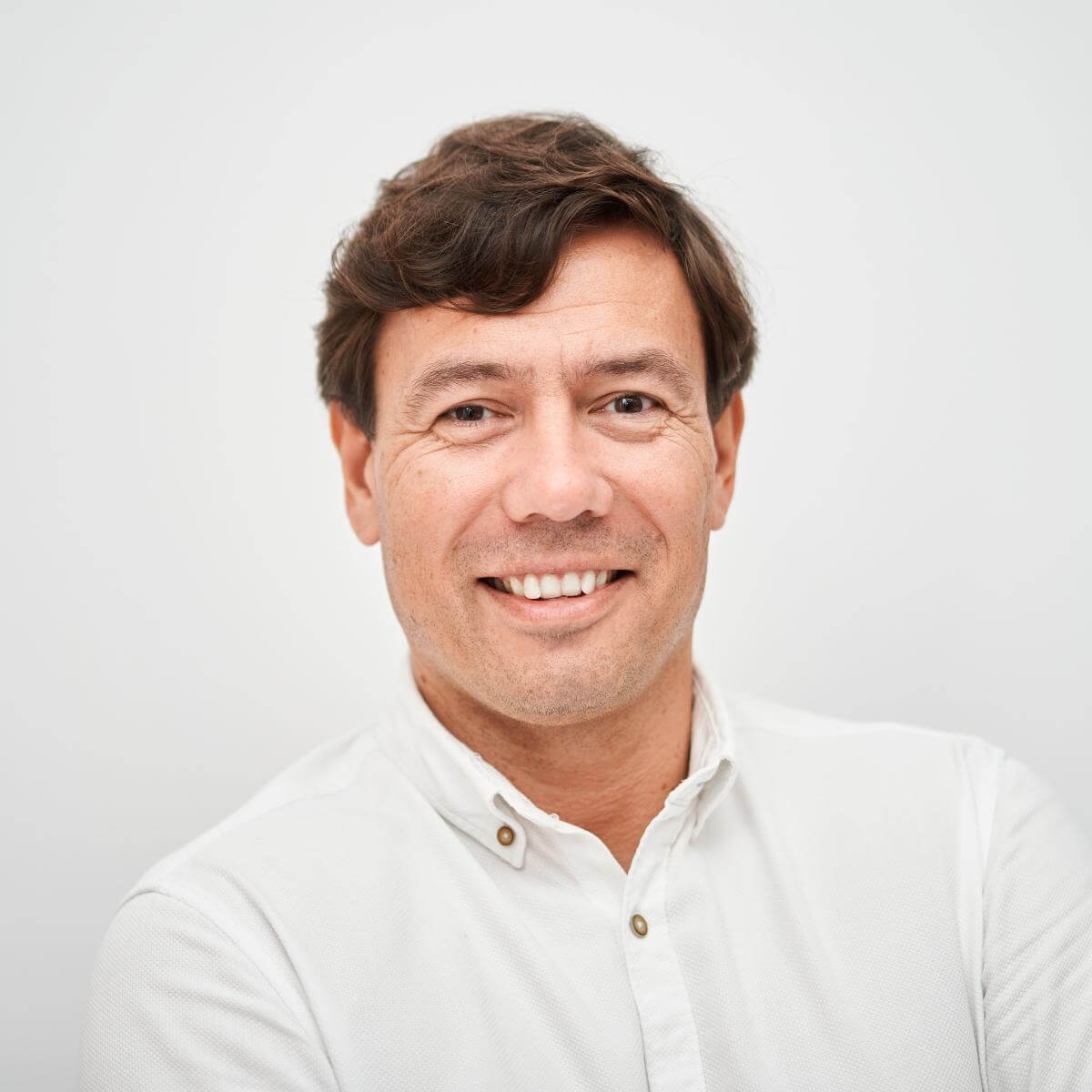 Michał Lejk. Portret uśmiechniętego mężczyzny w białej koszuli.