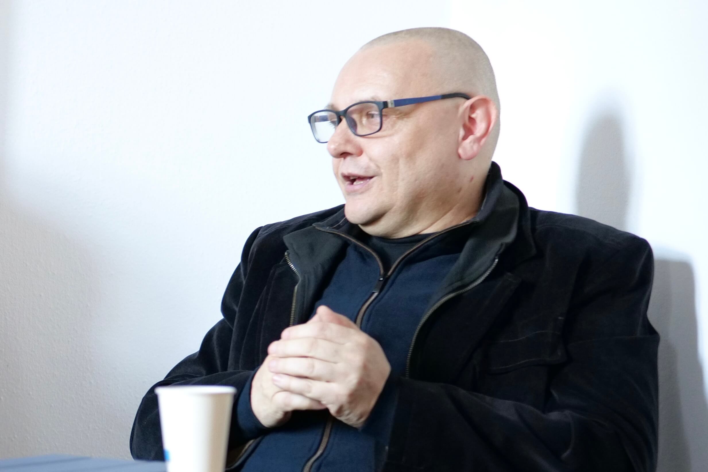 Prof. dr hab. Michał Kuziak. Zdjęcie przedstawia mężczyznę krótko ostrzyżonego w okularach. Ubrany jest w ciemną bluzę. zwrócony jest w prawą stronę.
